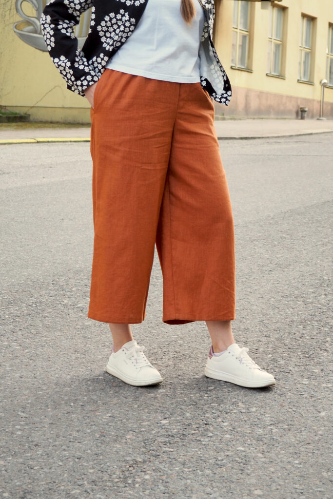 Kuvassa naisen alavartalo ja hänellä päällä kanelin sävyiset culottes-housut